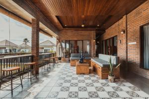 een terras met stoelen, een bank en tafels bij Big Brother Berawa Beach in Canggu