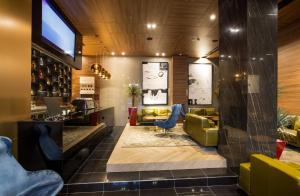 a lobby of a bar with chairs and a table at Ambasador Hotel in Niš