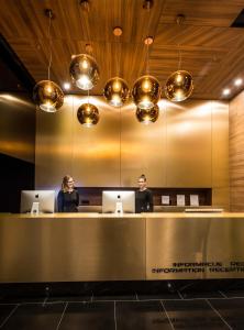 two people sitting at a reception desk with laptops at Ambasador Hotel in Niš