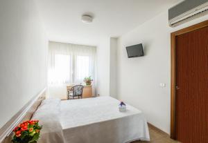 a white room with a bed and a window at Hotel Esperia in Alba Adriatica