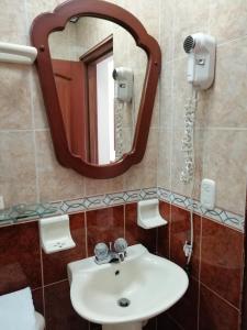 a bathroom with a sink and a mirror at Hotel Bolivar Plaza in Manizales