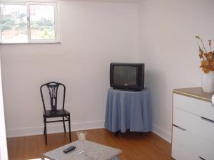 a room with a tv on a table and a chair at António Augusto Apartment in Coimbra
