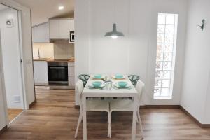 a white dining table and chairs in a kitchen at Loft acolhedor em Fátima perto do Santuário in Fátima