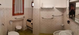 y baño con 2 aseos, lavamanos y espejo. en La Baita in Centro, en Roccaraso