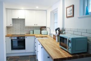 a kitchen with a counter with a microwave on it at Fal River Cottage in Truro