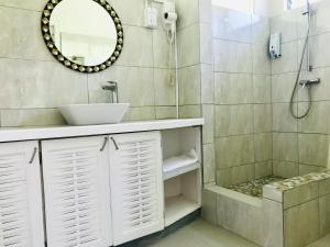 een badkamer met een wastafel en een douche bij Bougainvillea Apartments in Saint Georgeʼs