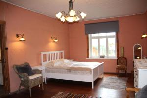 una camera da letto con un letto, una sedia e una finestra di Posti 22 külaliskorter a Haapsalu Altre 9 foto