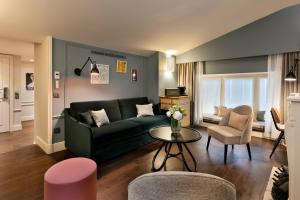 a living room with a green couch and a table at Royal Madeleine Hotel & Spa in Paris