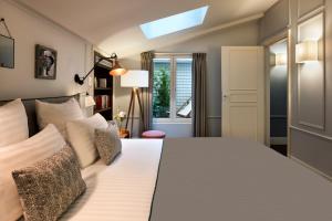 um quarto com uma cama grande e uma janela em Royal Madeleine Hotel & Spa em Paris