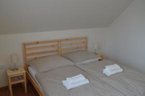a bed with two white towels on top of it at Apartmány Réví in Hlohovec