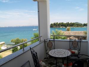 a balcony with a table and chairs and a view of the water at Villa Majer in Preko