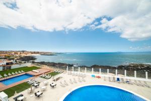 科拉雷侯Hotel Boutique TAO Caleta Mar的享有带游泳池和海洋的度假村的空中景致