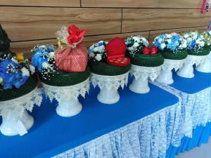 rząd kapeluszy z kwiatami na stole w obiekcie ตะวันอพาร์ทเม้นท์โฮเทลThawanapartmentHotel w mieście Satun