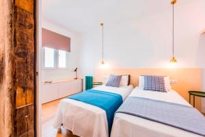two beds in a room with white and blue at Be Mate Gran Vía Suites in Madrid