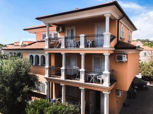 a large orange building with balconies and windows at Villa Dubravka in Lopar