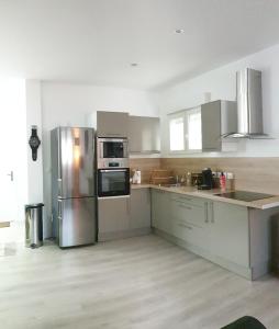 een keuken met een roestvrijstalen koelkast en apparatuur bij Appartement hyper-centre Epernay avec sauna et parking privé in Épernay