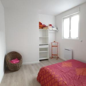 een slaapkamer met een bed, een raam en een stoel bij Appartement hyper-centre Epernay avec sauna et parking privé in Épernay