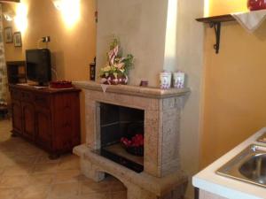 a stone fireplace in a kitchen with a sink at Il borgo 28 in Scapoli