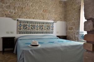 a bedroom with a bed with a hat on it at Hotel Goloritzé in Baunei