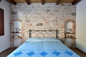 a bedroom with a brick wall and a bed at Hotel Goloritzé in Baunei
