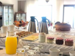 una mesa con un buffet de productos para el desayuno y zumo de naranja en BHDouro en Baião