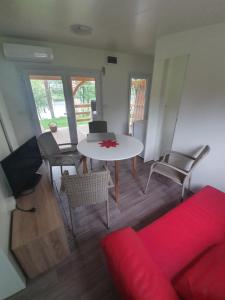 a living room with a red couch and a table at kamp katra mobilna hiška EXCLUSIVE in Vinica +19 photos