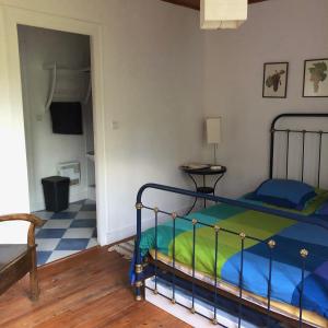 - une chambre dotée d'un lit avec un couvre-lit bleu et vert dans l'établissement Château Régaldo-Saint Blancard, à Salleboeuf