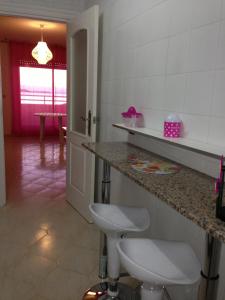 cocina con encimera y taburetes en una habitación en Apartamentos Neptuno GL V.v., en La Manga del Mar Menor