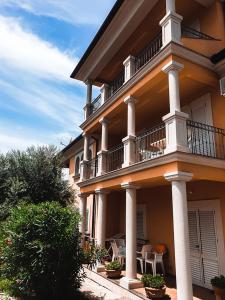 a large building with a balcony and tables and chairs at Villa Dubravka in Lopar