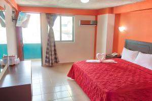 ein Schlafzimmer mit einem roten Bett und einem Fenster in der Unterkunft Hotel ROLOVI in Veracruz