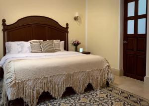 1 dormitorio con 1 cama grande con sábanas y almohadas blancas en Casa Tavera- Adults Only en Mérida