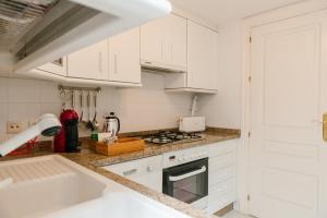 a kitchen with white cabinets and a stove top oven at Cordoba COol Vailima in Córdoba