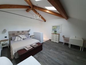 ein Schlafzimmer mit einem großen Bett, einem Schreibtisch und einem Stuhl in der Unterkunft Agriturismo Podere Nigriano in Salò