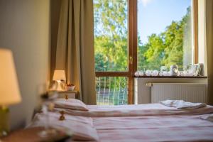 a bedroom with a bed and a window with a view at Przystań Przy Lesie in Jantar