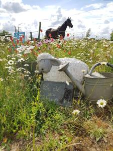 un animal de peluche está sentado en un campo de flores en La clef des champs 3, en Meillac