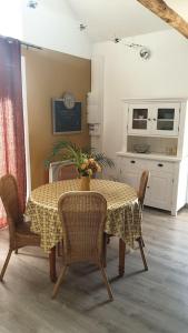 a dining room with a table and chairs and a kitchen at La clef des champs 3 in Meillac +4 photos