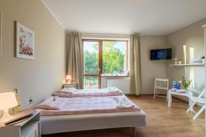 Un dormitorio con una cama grande y una ventana en Przystań Przy Lesie, en Jantar