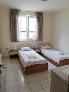 ein Hotelzimmer mit 2 Betten und einem Fenster in der Unterkunft Guest House Dimovi in Sozopol