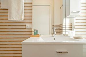 uma casa de banho com um lavatório branco e um espelho. em My Home-Gorgona em Livorno