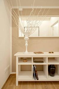 un tavolo bianco con un vaso davanti a uno specchio di My Home-Gorgona a Livorno