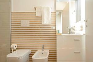 bagno con servizi igienici, lavandino e specchio di My Home-Gorgona a Livorno