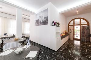 a kitchen with white walls and a table and a counter at Hotel Promenade in Gabicce Mare