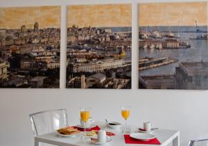 uma mesa branca com dois quadros na parede em Genova46 Suites & Rooms em Génova