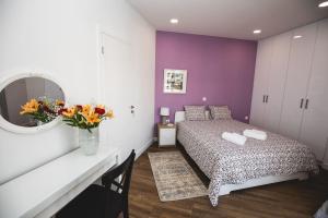 ein Schlafzimmer mit einem Bett, einem Spiegel und Blumen in der Unterkunft Gaspar Apartment - 4th floor - Renovated 2019 in Athen