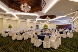 une salle de banquet avec des tables blanches et des chaises blanches dans l'établissement San Nicolas Hotel Casino, à Ensenada