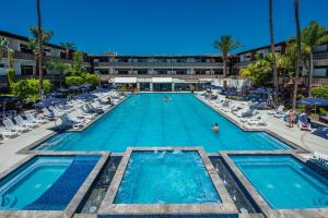 a large swimming pool with chairs and a hotel at San Nicolas Hotel Casino in Ensenada
