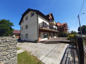 duży biały dom z kamienną ścianą w obiekcie Apartamenty i Domki Mierzeja w Sztutowie