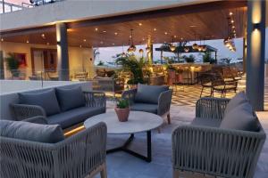 a patio with couches and a table and chairs at Singular Joy Downtown Residences in Playa del Carmen