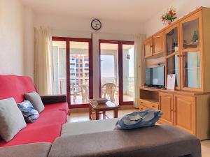 a living room with a red couch and a tv at Verdemar 2007 - Resort Choice in La Manga del Mar Menor