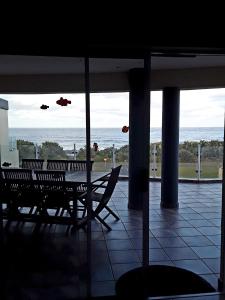 a patio with a table and chairs and the ocean at 12 Uvongo Breeze in Uvongo Beach